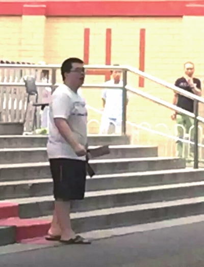 左一:男子當街手持兩把菜刀。